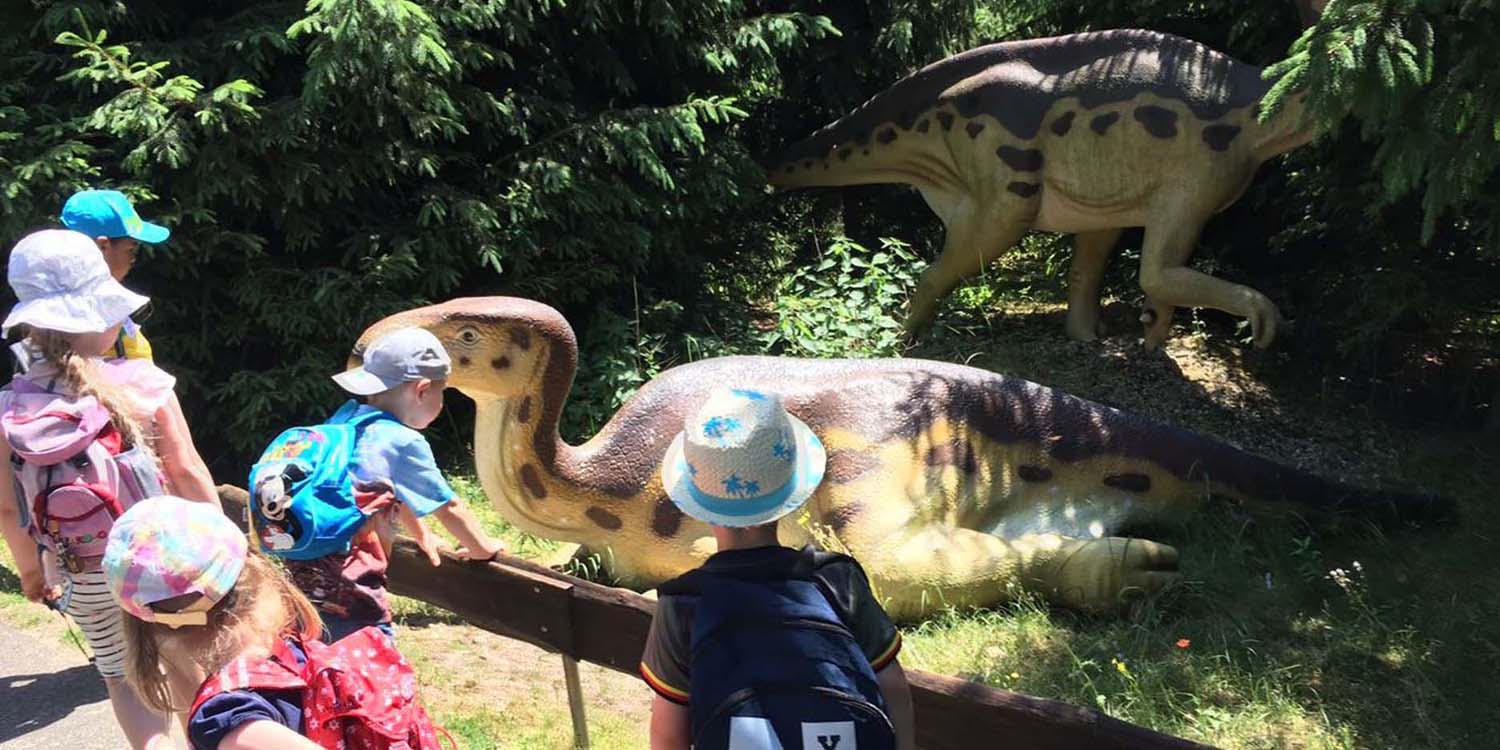 Einige Kinder bestaunen dargestellte Dinosaurier