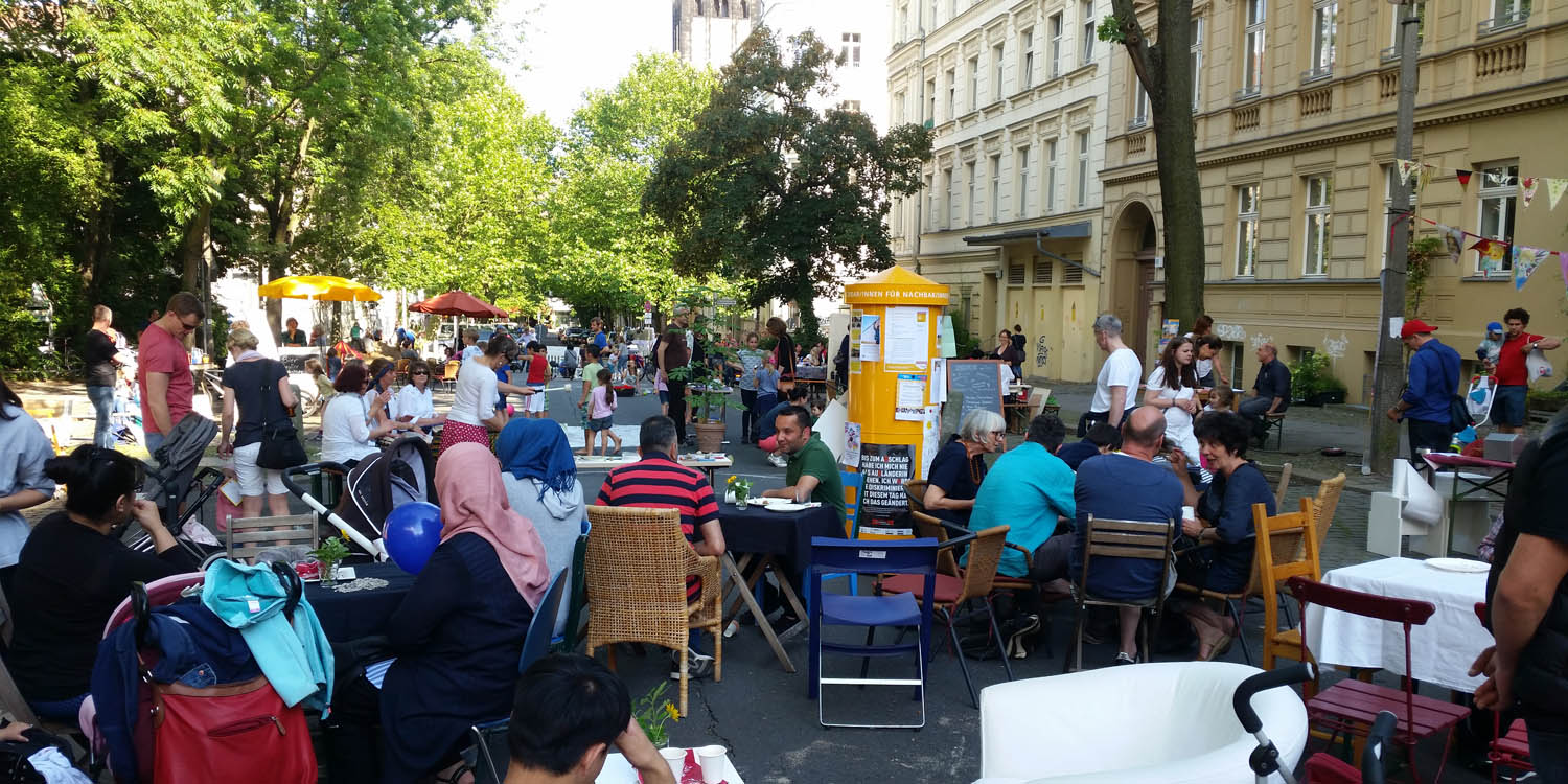 Viele Leute, die auf einem Straßenfest sitzen