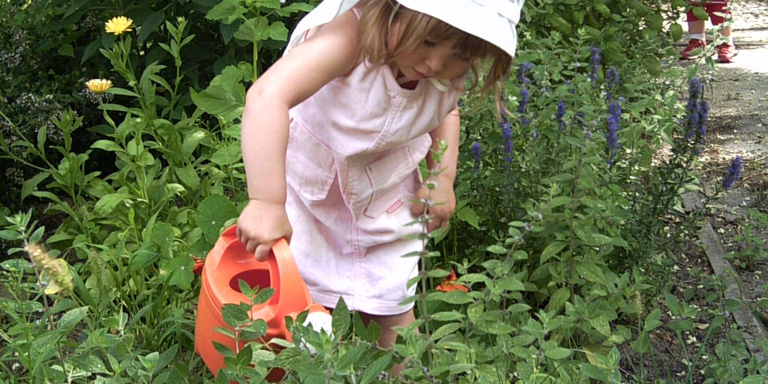 Mädchen gießt Pflanzen