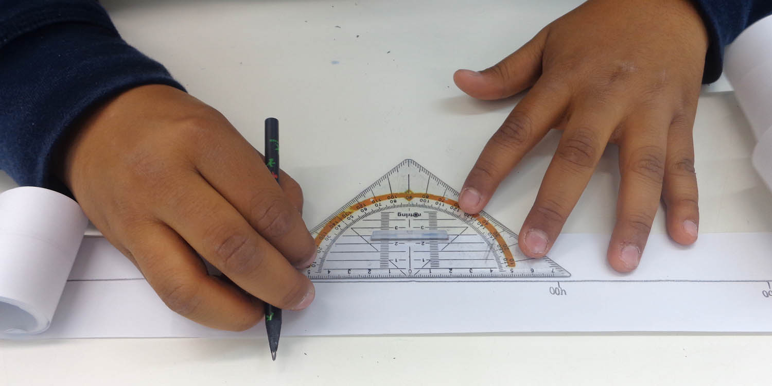 Zwei Hände zeichnen mit Hilfe eines Geodreicks eine gerade Linie auf einem Blatt Papier.