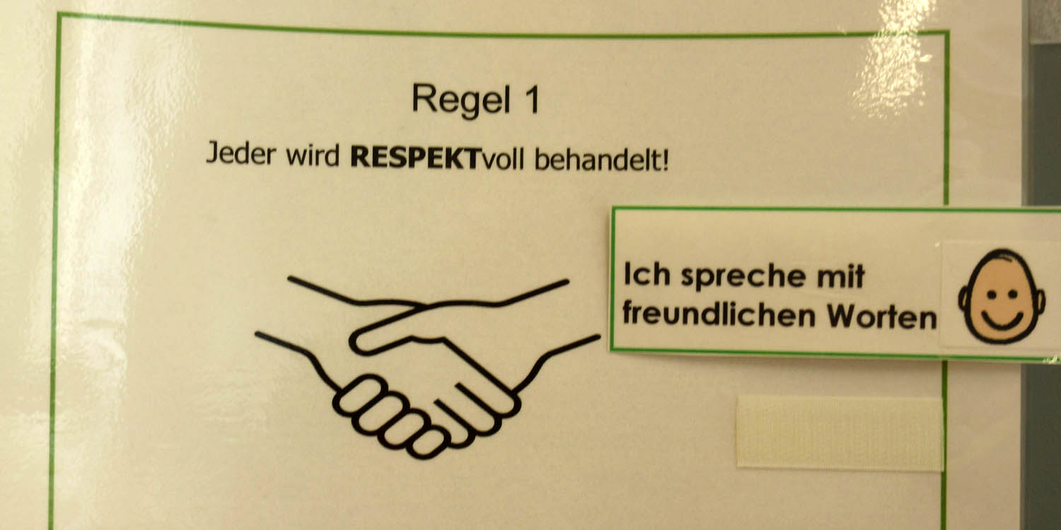 Aufgeschriebene Regeln, wie "alle werden respektvoll behandelt" stehen an einem Flipchart und gelten für alle Schüler/innen.