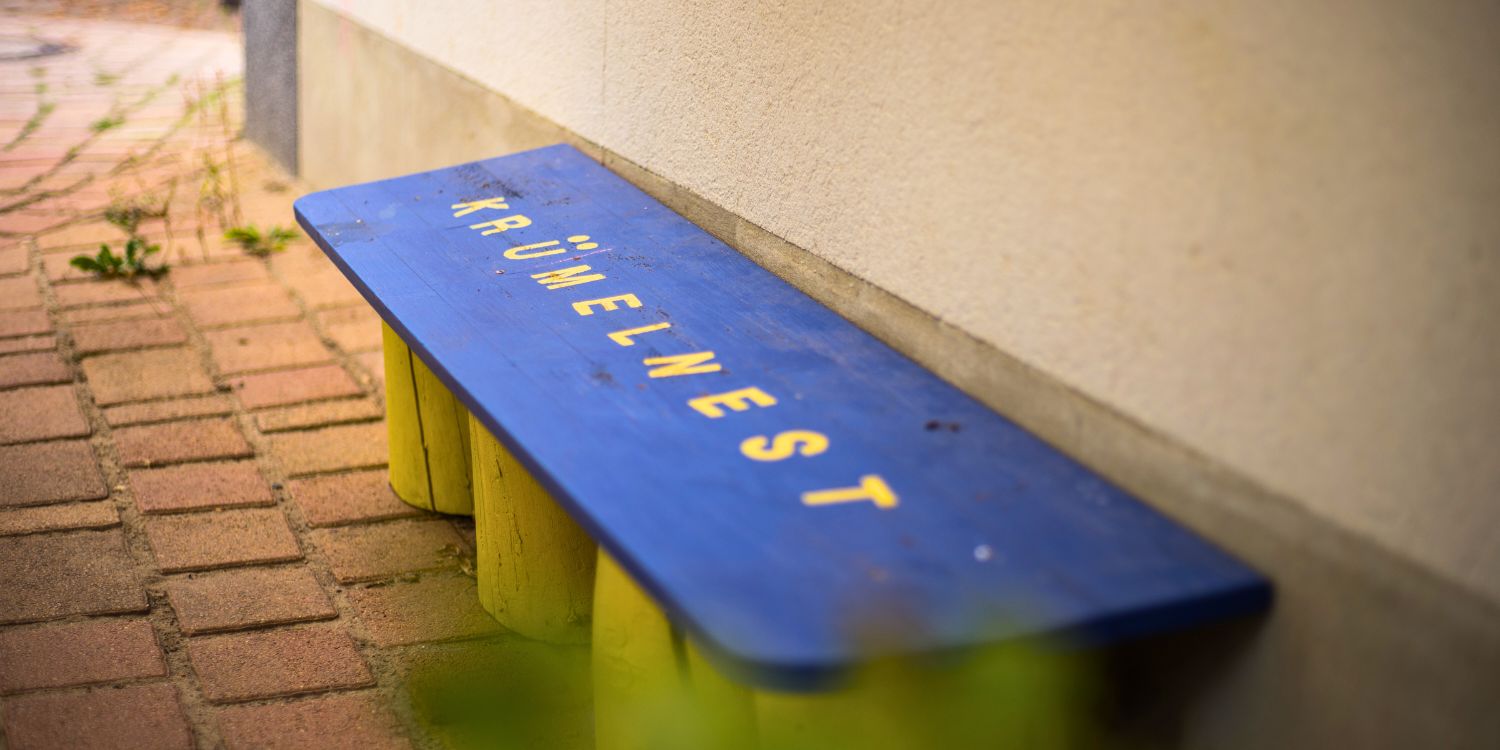 Auf einer Bank steht geschrieben "Krümelnest"