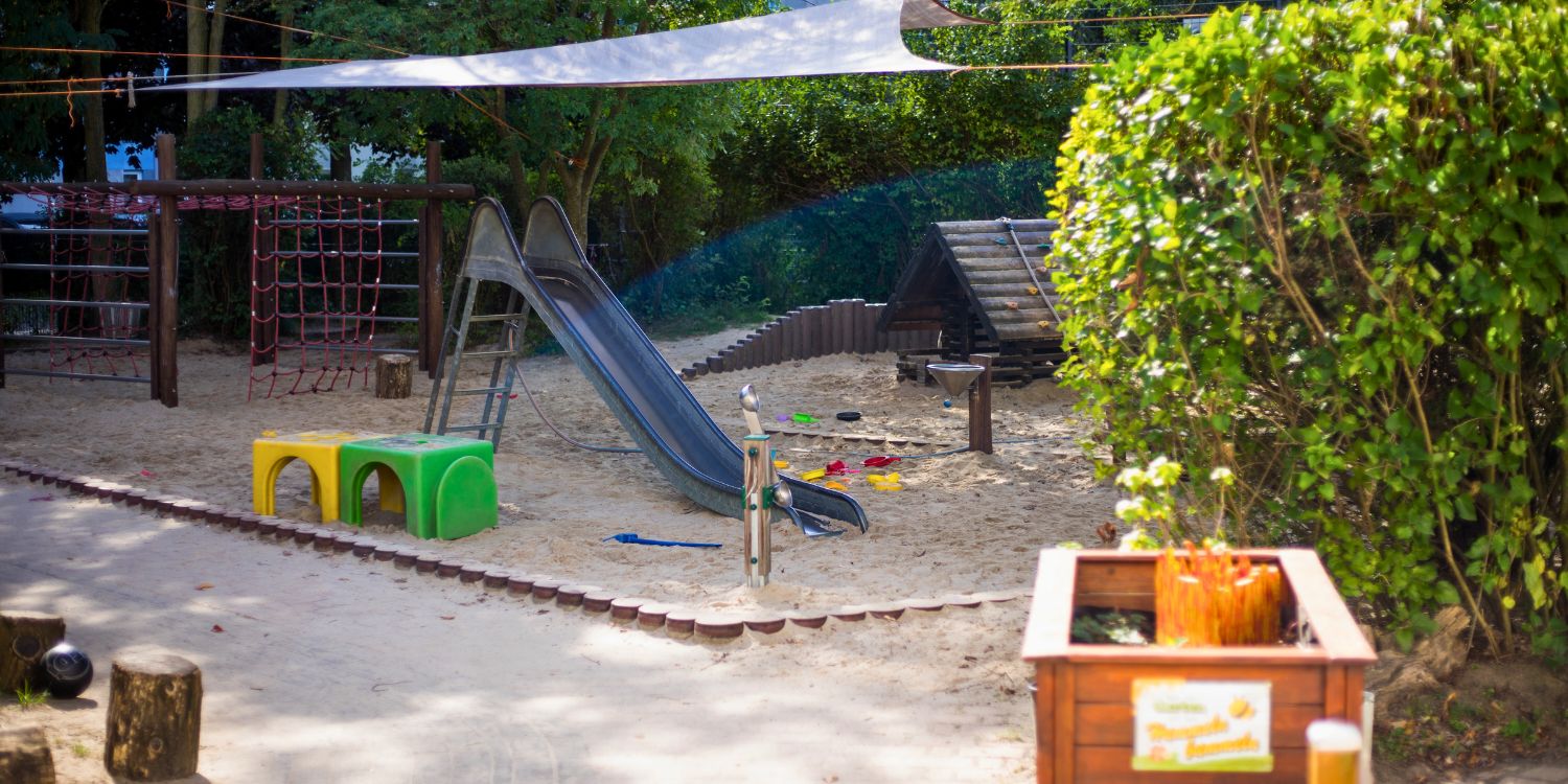 Klettergeräte stehen im Garten mit Sandkasten