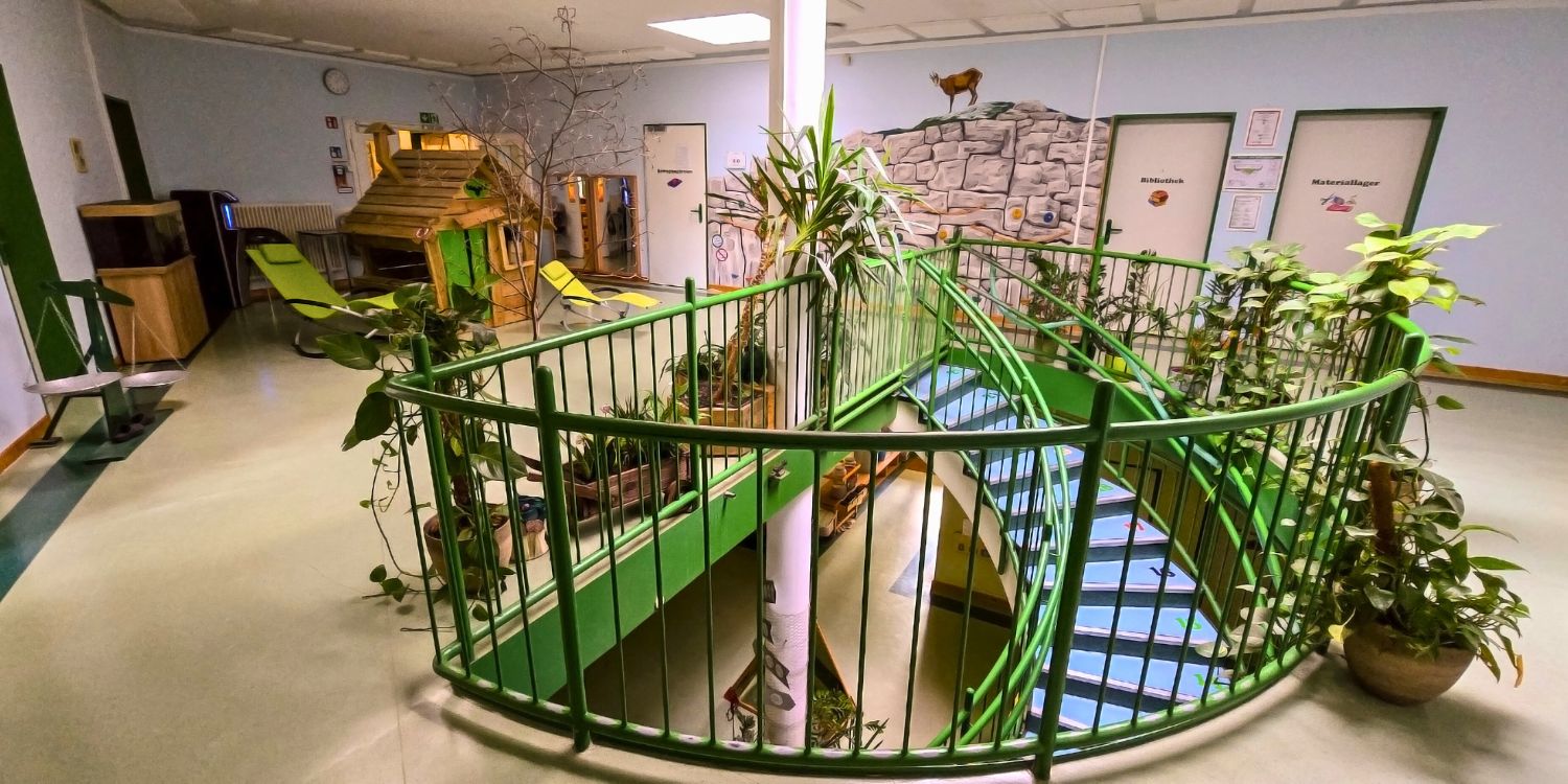 Treppengeländer mit kleinem Holzhaus und Türen rundherum